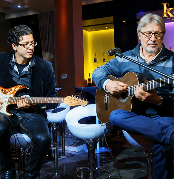 Houssam playing guitar with another musician